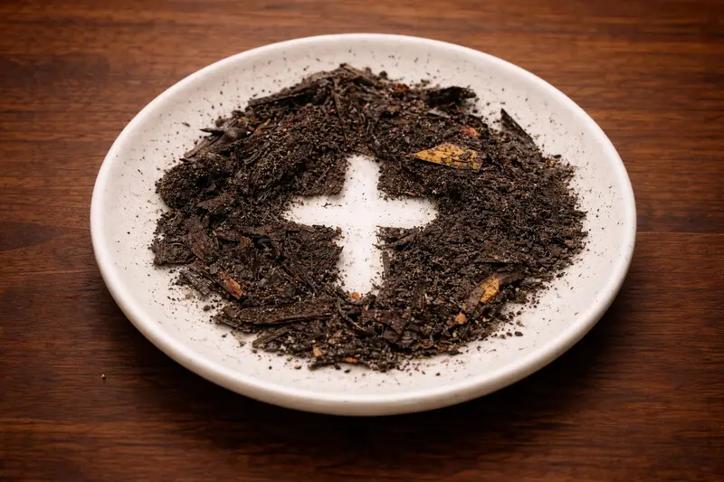 popel ve tvaru kříže na bílém talířku jako symbol Popeleční středy